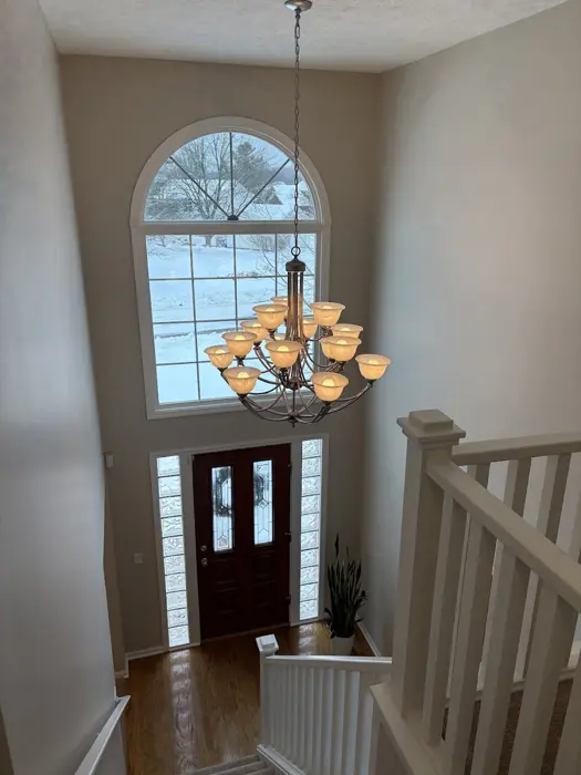 Two-story foyer with arched window and chandelier